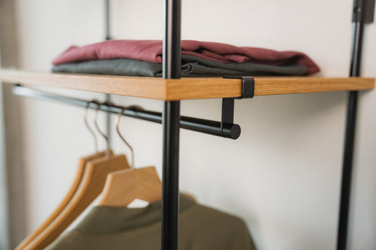 Folded clothes and hanging garments on KUUDU modular oak wardrobe