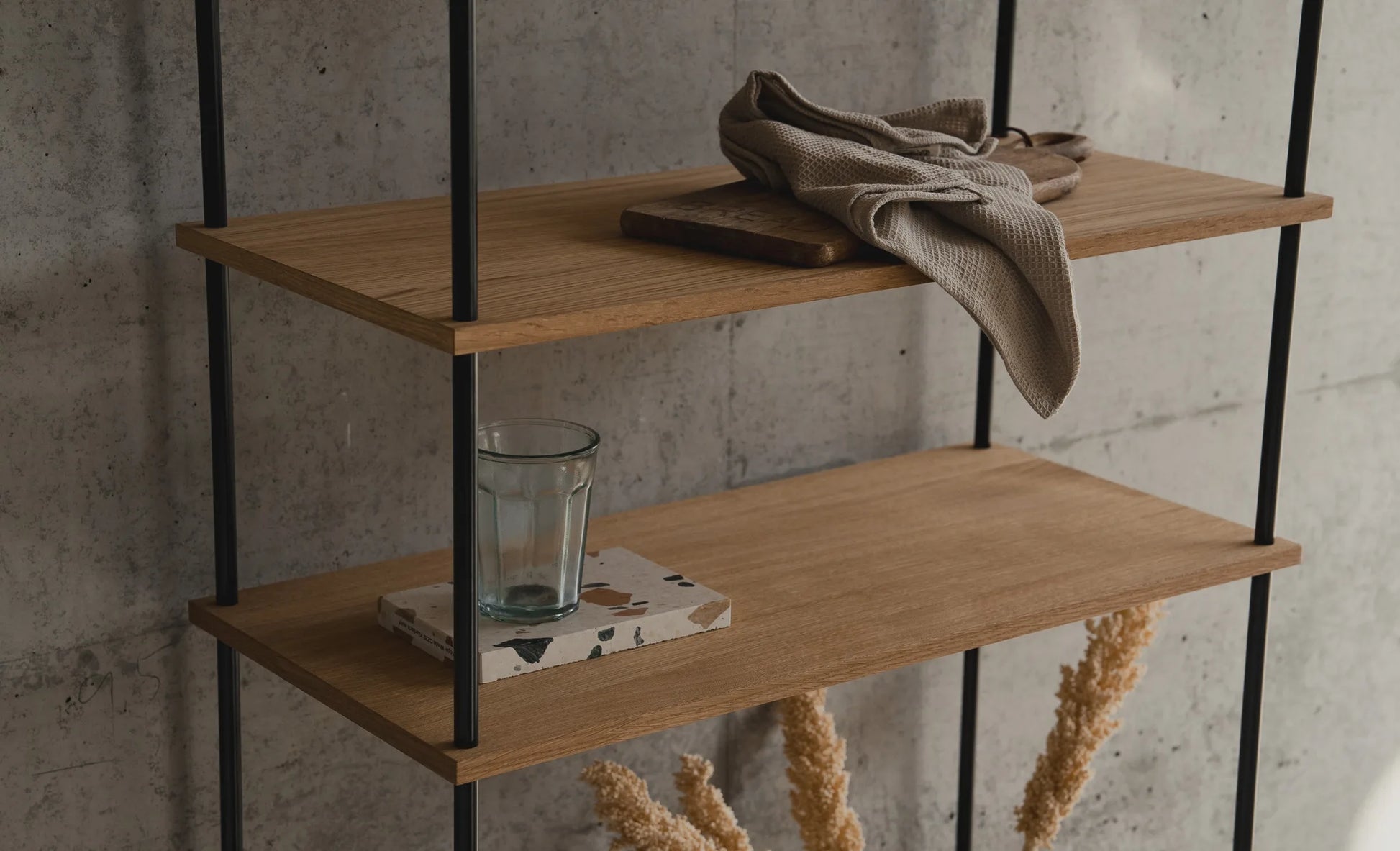 KUUDU Regalsystem — Eichenböden und schwarze Stahlpfosten vor Betonwand